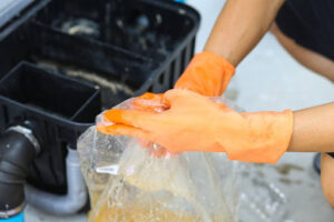 A person cleaning a grease trap.