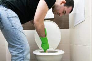 A man plunging a toilet.