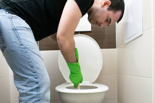 A man plunging a toilet.